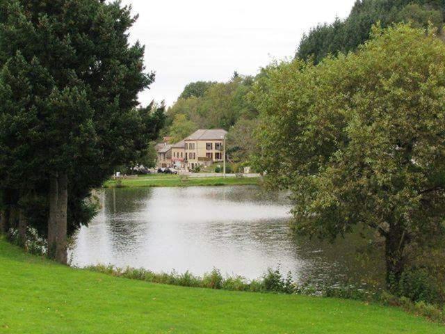 un lac en face d'une maison à côté d'une maison dans l'établissement Au beau séjour, à Mayet-de-Montagne