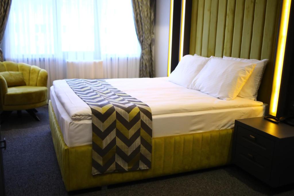 Habitación de hotel con cama y silla en GRAND DORA HOTEL, en Ankara