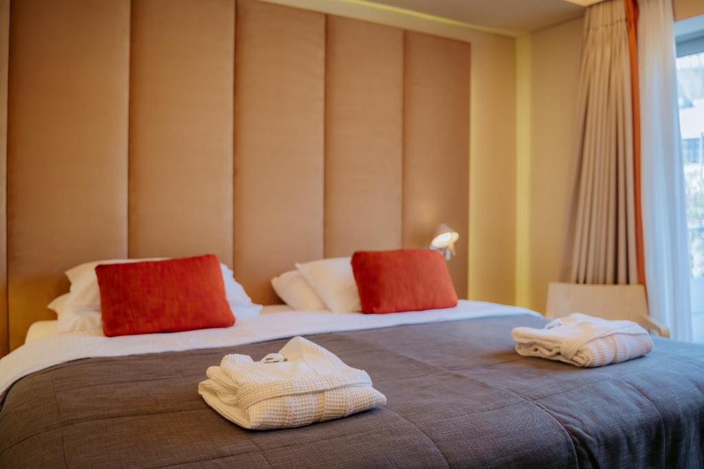 two beds in a hotel room with towels on them at Herodion Hotel in Athens