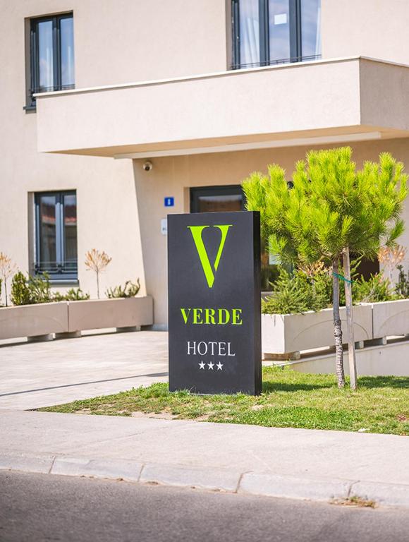 ein Schild für ein Hotel vor einem Gebäude in der Unterkunft Hotel Verde in Podgorica