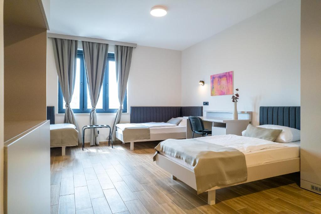 Hotel Verde في بودغوريتسا: غرفة فندقية بسريرين وطاولة