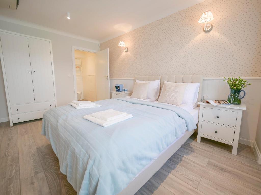 a bedroom with a large bed with blue sheets and white pillows at Flatbook - Old Town Apartments Spichrzowa 21 in Gdańsk