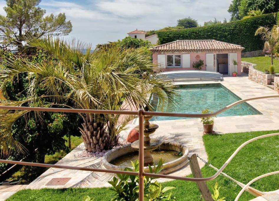 a swimming pool with a fountain in a yard at Adorable Maison Indépendante 30m2 avec Piscine en saison in Cabris