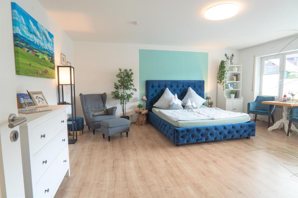 1 dormitorio con 1 cama azul y 1 silla en Ferienwohnung BergPfote en Scheidegg