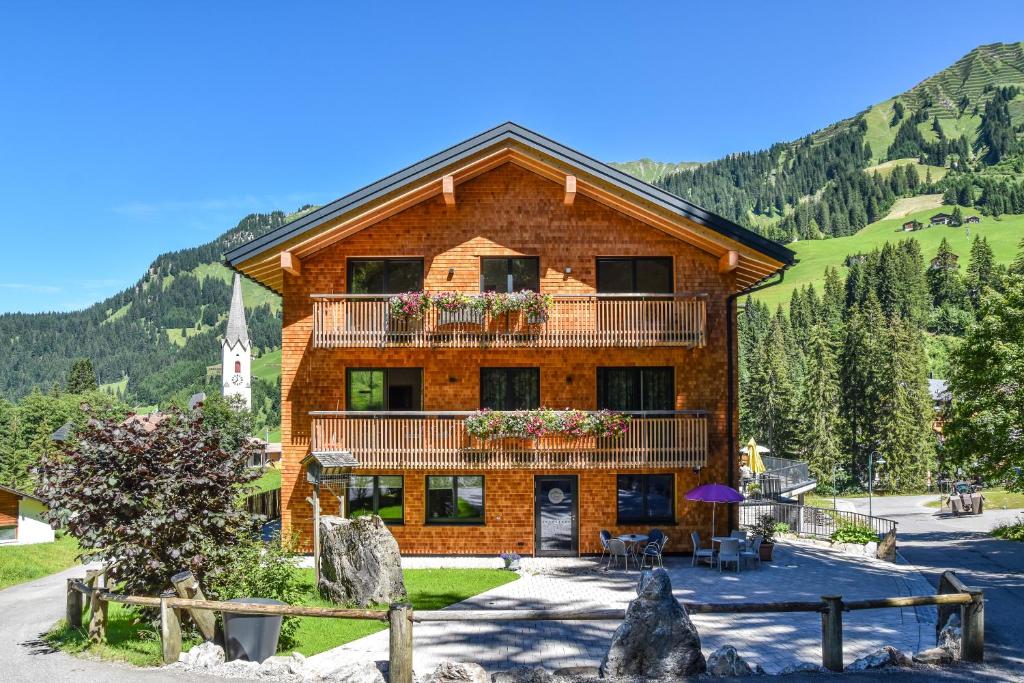 a log house with a balcony on a mountain at Lisas - with Wellness and Breakfast in Schröcken