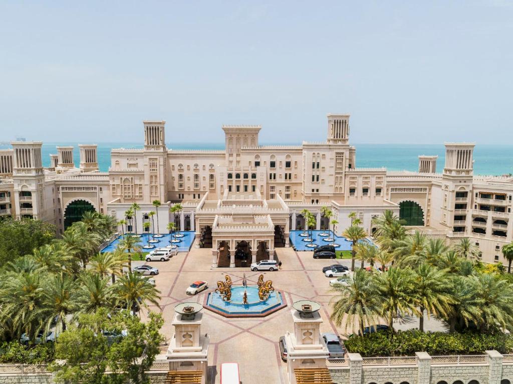 ドバイにあるJumeirah Al Qasr Dubaiのヤシの木が目の前に広がる建物