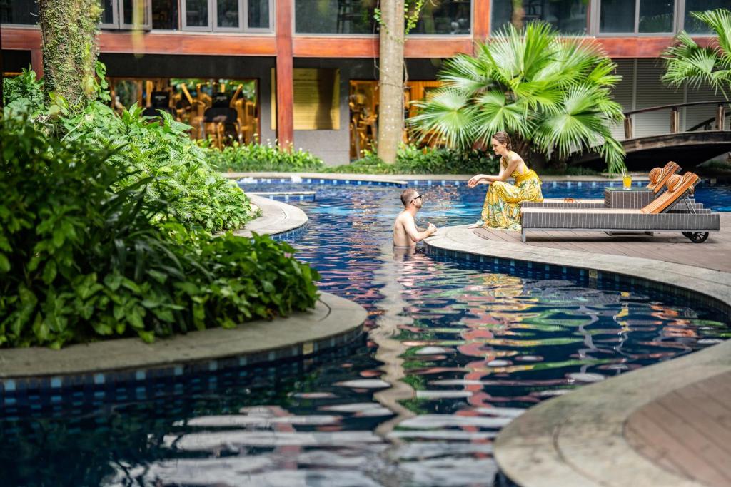 uma mulher e uma criança brincando na piscina em Fraser Suites Hanoi em Hanói
