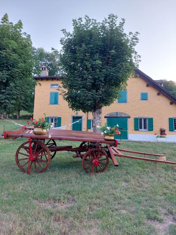 um carrinho vermelho com flores em frente a um edifício em AL CASALE SANT' ANNA PELAGO em SantʼAnna Pelago