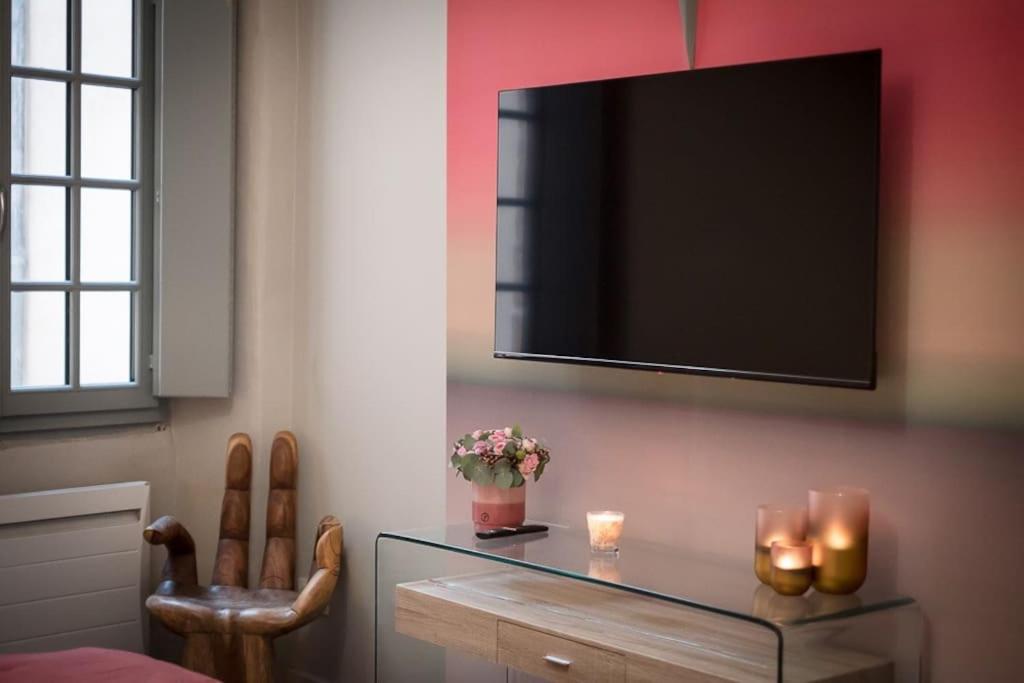 TV a/nebo společenská místnost v ubytování room five - parking, balnéothérapie, place nationale, un havre de paix