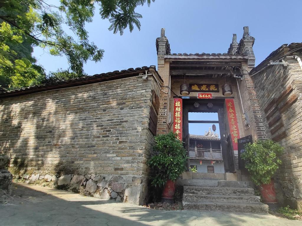 wejście do budynku z ceglaną ścianą w obiekcie Yangshuo Loong Old House w mieście Yangshuo