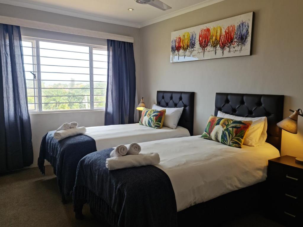 a bedroom with two beds with towels on them at Africatamna Self Catering House in Durban