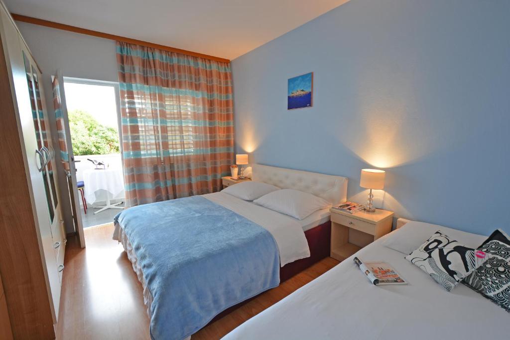 a hotel room with two beds and a window at ꕥ ROOMS SUNCE, Family choice, Best Panoramic view, Supetar Island Brac in Supetar