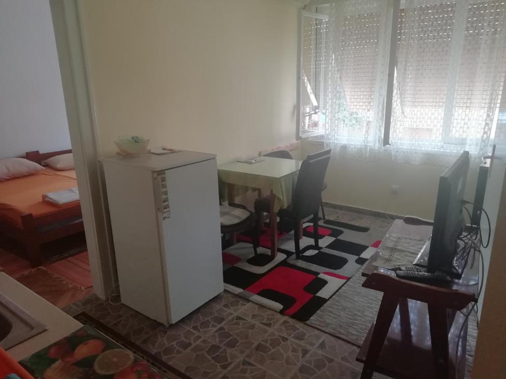 Zimmer mit einem Schreibtisch und einem Tisch mit 2 Stühlen in der Unterkunft Centar Herceg Novi in Herceg-Novi