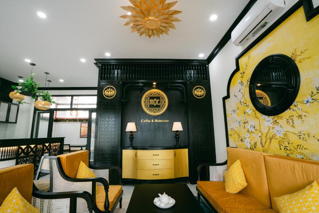 フーコックにあるMộc Homestay GrandWorld Phú Quốcのソファ、椅子、テーブルが備わる客室です。
