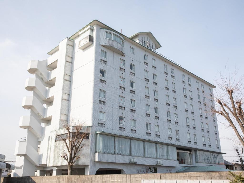 a large white building with a lot of windows at Hotel Castle Inn Yokkaichi in Yokkaichi