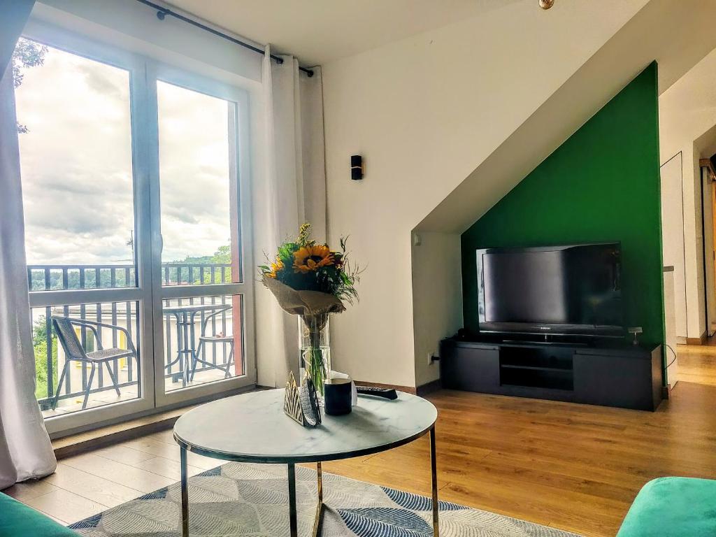 Televízia a/alebo spoločenská miestnosť v ubytovaní Zielony apartament z widokiem na jezioro