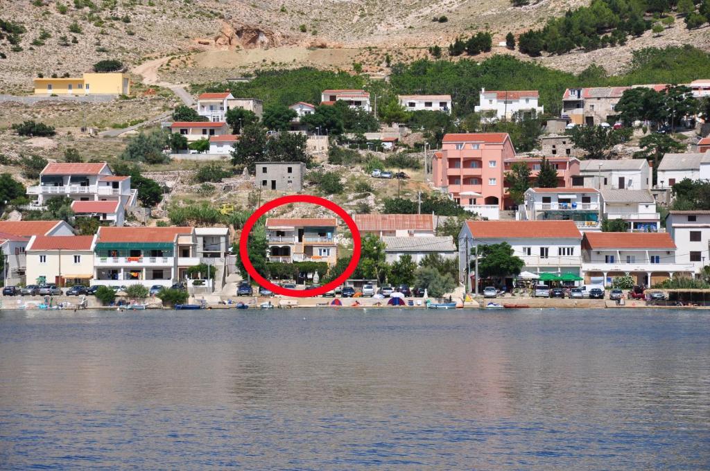 a red circle in the middle of a city next to the water at Apartments by the sea Metajna, Pag - 6352 in Metajna