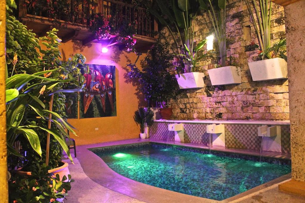 a swimming pool in front of a brick wall with plants at Hotel Casa Gloria Boutique in Cartagena de Indias