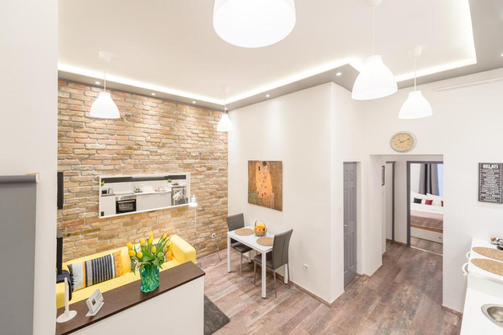 eine Küche und ein Wohnzimmer mit einer Ziegelwand in der Unterkunft Venus Apartments - Almassy Park in Budapest