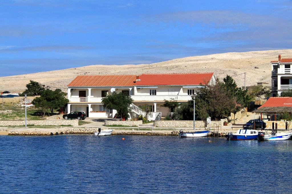 una casa sull'acqua con barche in acqua di Apartments by the sea Kustici, Pag - 6355 a Kustići