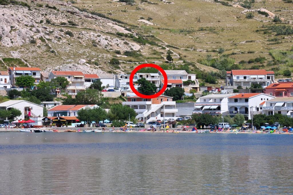 um círculo vermelho sentado ao lado de um lago em Apartments with a parking space Metajna, Pag - 6423 em Metajna
