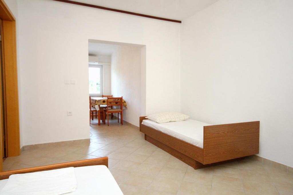 sypialnia z łóżkiem, lustrem i stołem w obiekcie Family friendly seaside apartments Kustici, Pag - 6376 w mieście Kustići