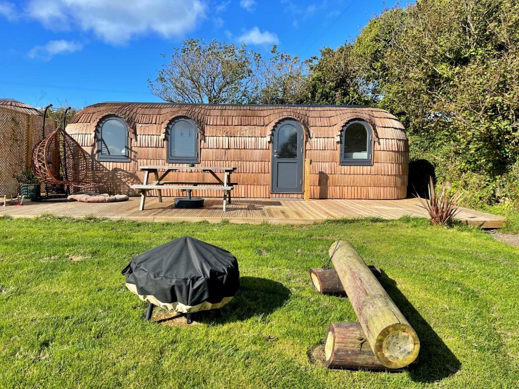 a building with a tent in the grass at Finest Retreats - Clotted Cream Cabin in East Looe