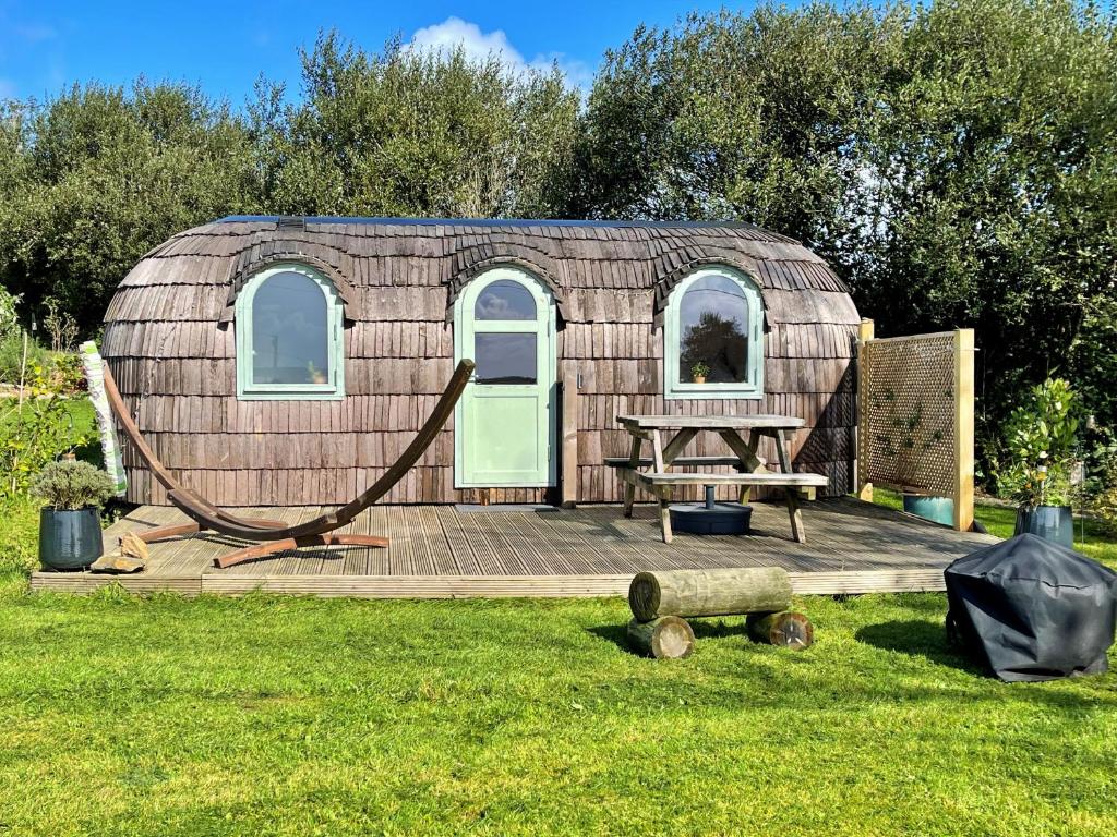 a yurt with a wooden deck in the grass at Finest Retreats - Prosecco Cabin in East Looe