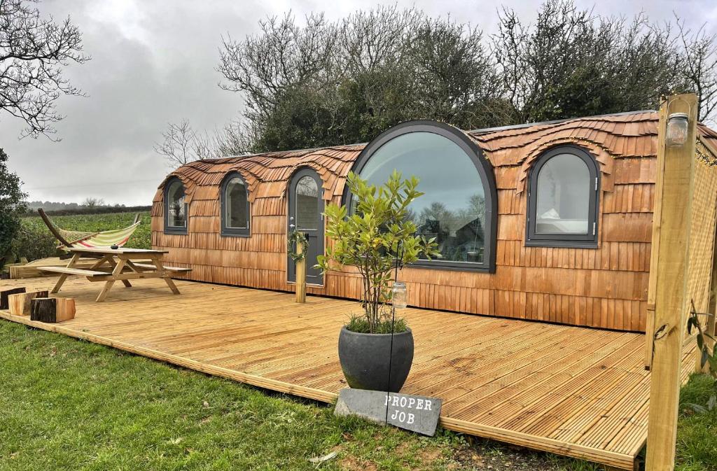 una casetta minuscola con una terrazza in legno e un tavolo da picnic di Finest Retreats - Proper Job Cabin a East Looe