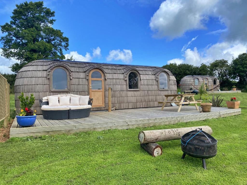 a yurt with a couch and a table in a yard at Finest Retreats - The Pasty Cabin in East Looe