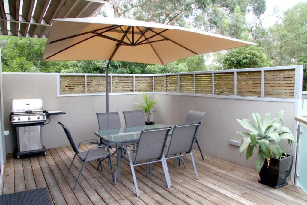 a patio with a table and an umbrella at La mer in Inverloch