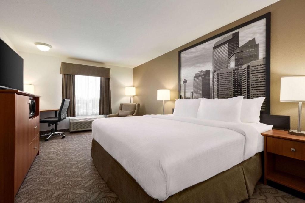 A bed or beds in a room at Super 8 by Wyndham Calgary Shawnessy Area