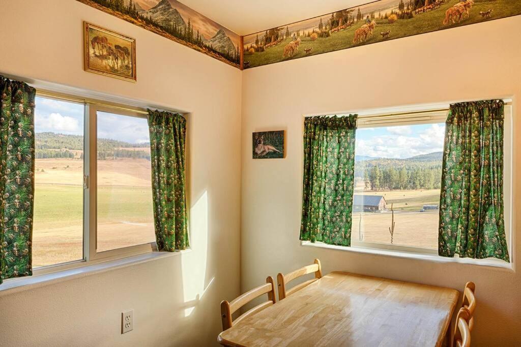 - une salle à manger avec une table et deux fenêtres dans l'établissement Hideaway Cabin - Eden Valley, à Oroville