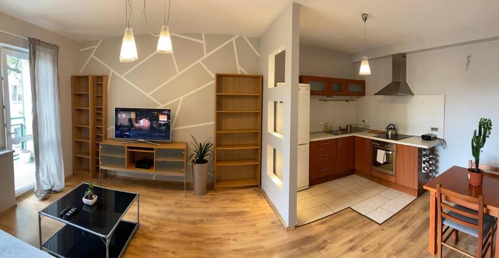 a kitchen and living room with a refrigerator and a table at Murano Apartaments Nova Praga in Warsaw
