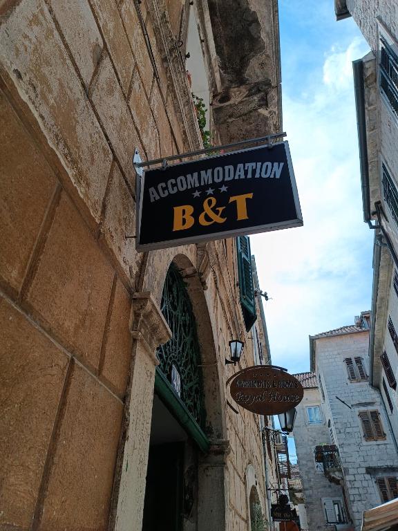 una señal para un restaurante al lado de un edificio en Guesthouse BiT Accommodation, en Kotor