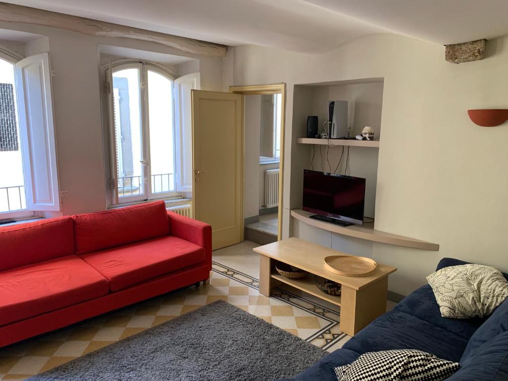 ein Wohnzimmer mit einem roten Sofa und einem TV in der Unterkunft Appartamento in centro storico a Lucca in Lucca