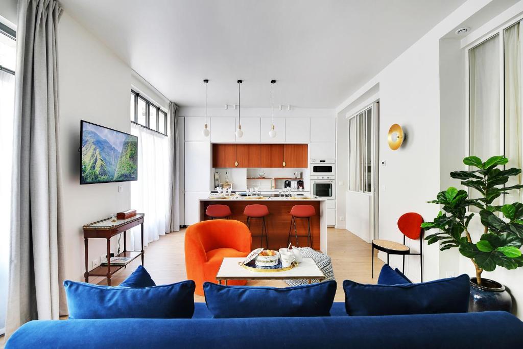 un salon avec un canapé bleu et une cuisine dans l'établissement Chic Apartment -2BR-6P- Invalides, à Paris