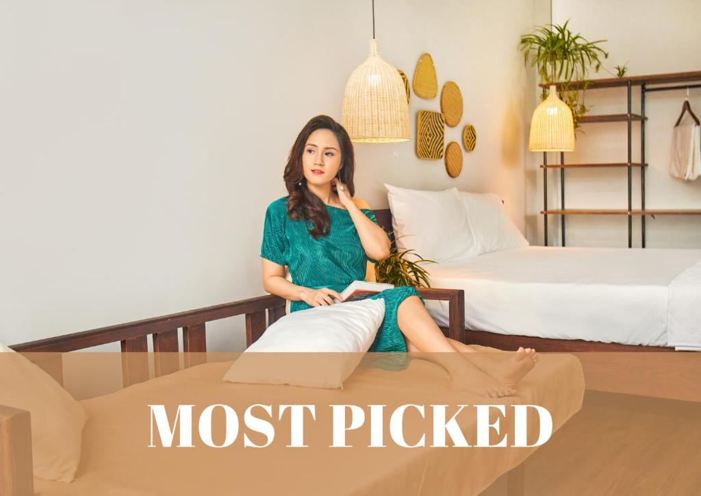 eine Frau, die auf einem Bett in einem Zimmer sitzt in der Unterkunft Entire Cosy Apartments May Homestay Hanoi in Hanoi