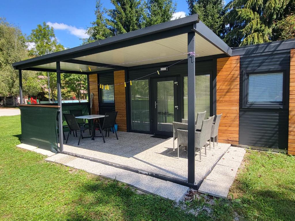 a pavilion with a table and chairs in a yard at Kamp Katra Mobilna hiška ECO in Vinica