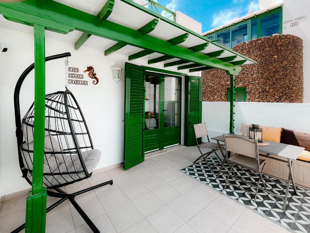 a patio with a green pergola and a table and chairs at Apartamento Maëlle Playa Blanca in Playa Blanca