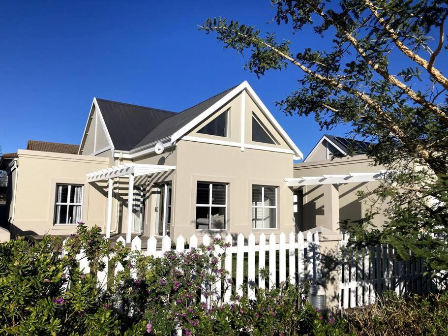 a white fence in front of a white house at Kingswood Gardens No. 4 in George