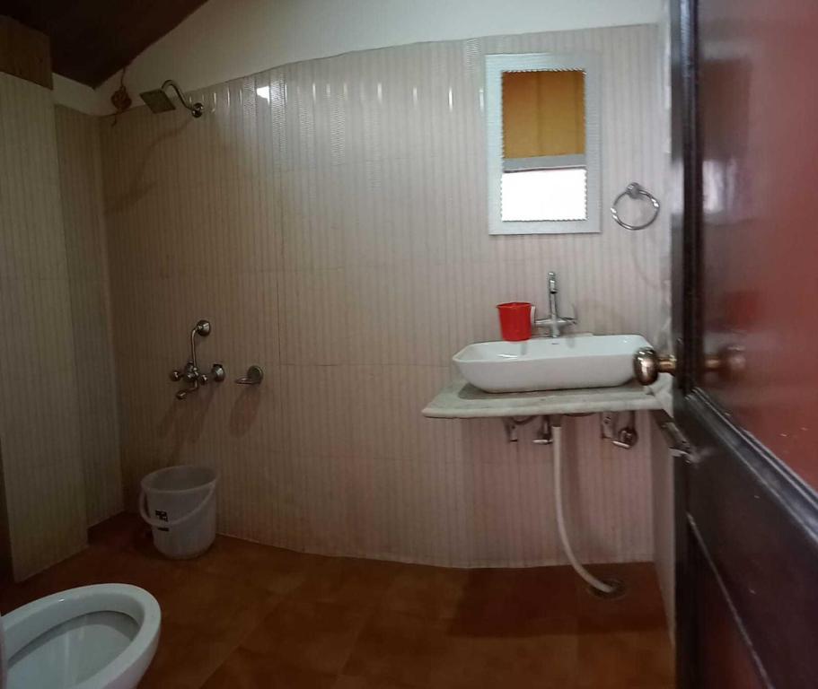 SPOT ON Hotel Rudra في كولو: حمام مع حوض ومرحاض