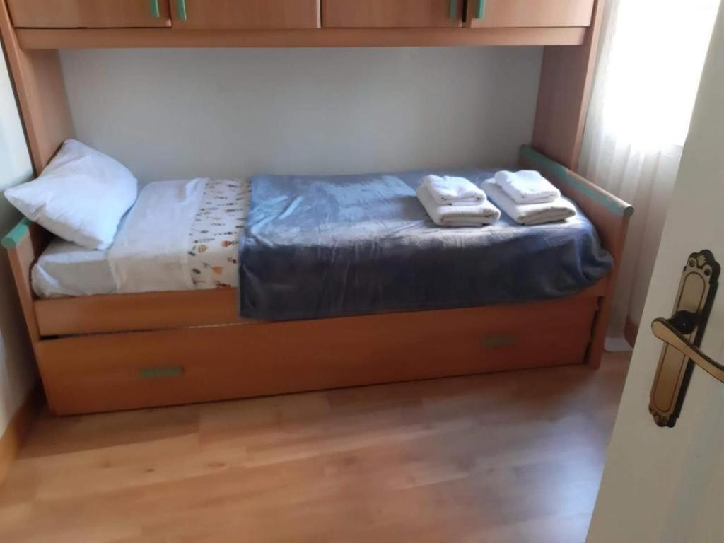 uma cama num quarto com duas toalhas em Rooms 2 and 1 Beds near Sevilla Center em Sevilha