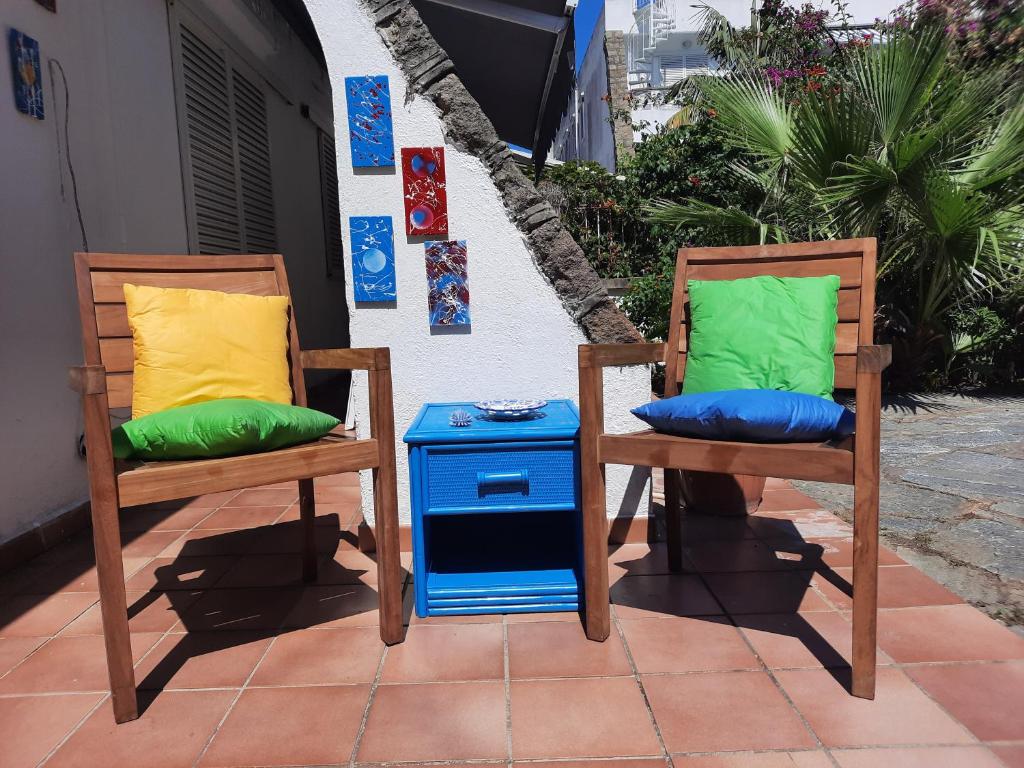 2 Stühle mit bunten Kissen neben einem Tisch in der Unterkunft Casa Antonietta in Ischia