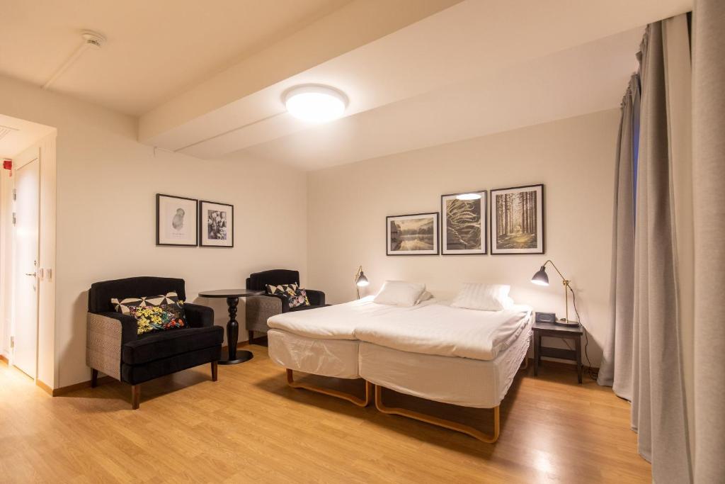 a bedroom with a bed and a couch and a chair at Hotell Mörby - Danderyd Hospital in Danderyd