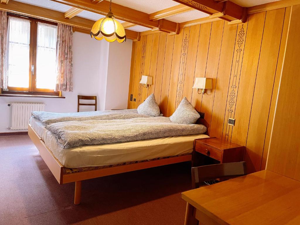 um quarto com uma cama grande num quarto em Hotel Gemmi em Leukerbad