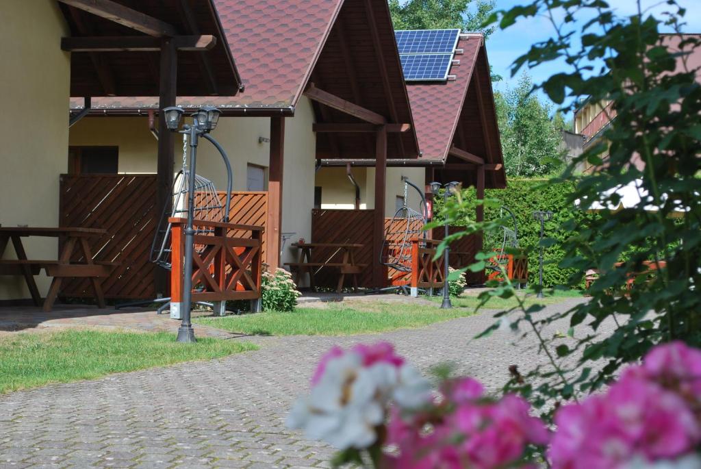 a house with a fence and some pink flowers at Kameleon Dźwirzyno in Dźwirzyno