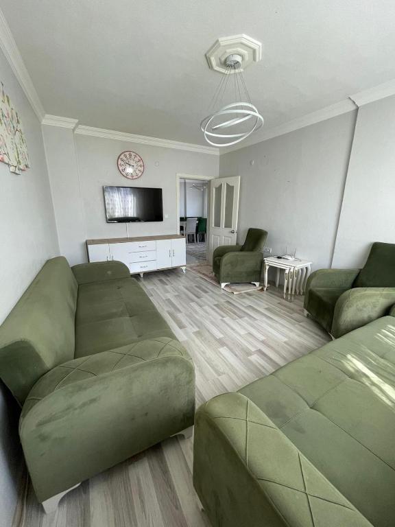 uma sala de estar com dois sofás verdes e uma televisão em Welcome 10 em Istambul