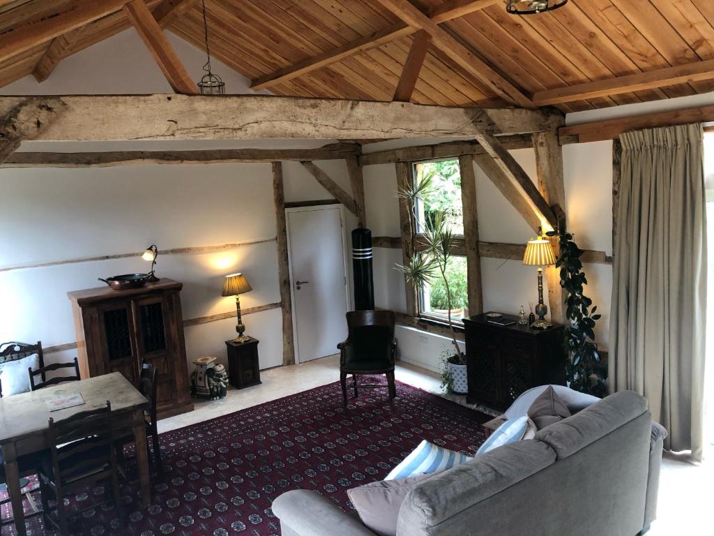 a living room with a couch and a table at The Barn in Romsey