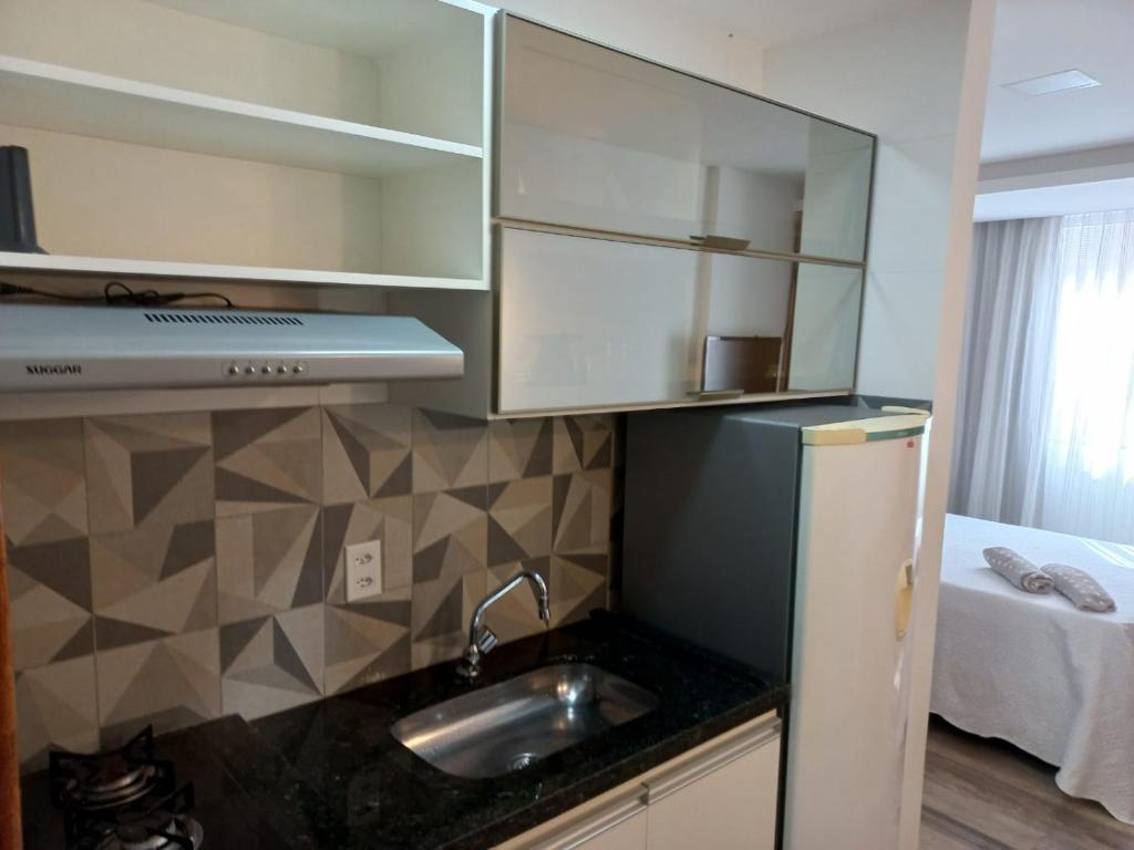 eine kleine Küche mit Spüle und Kühlschrank in der Unterkunft FLAT Beverly Hills 401B in Vila Velha